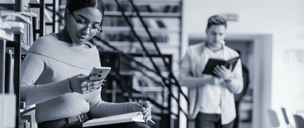 A sitting woman who is staring intently at her smartphone